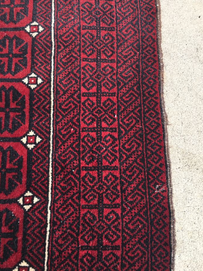 The same Baluch rug border after restoration