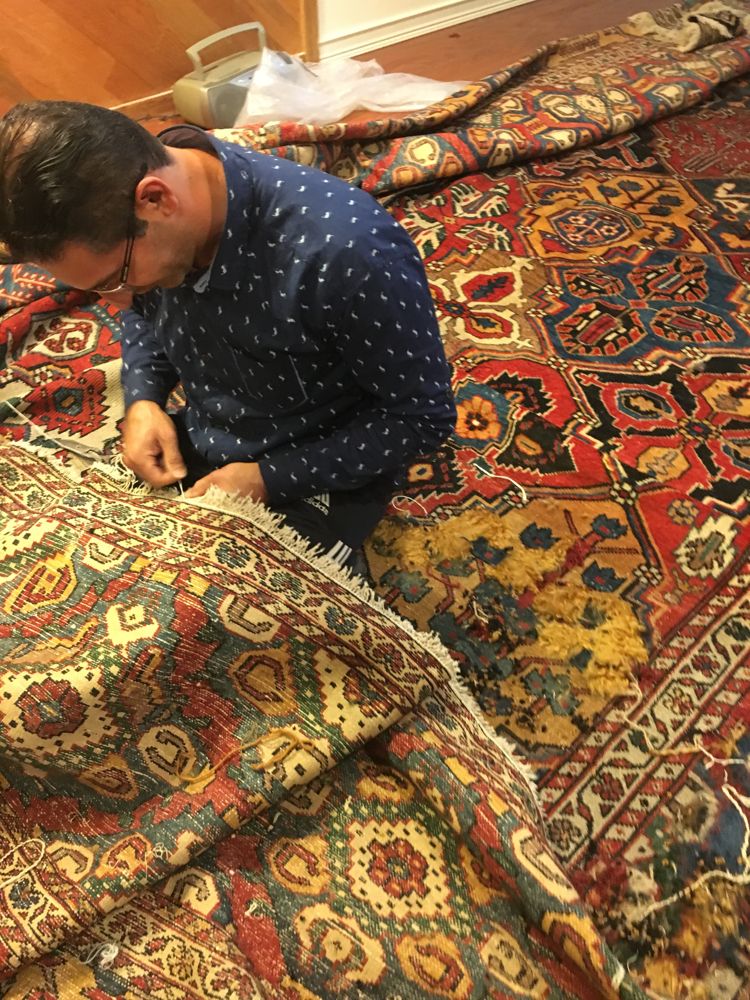 Newport Rugs craftsman hand-repairing the antique Bakhtiari rug
