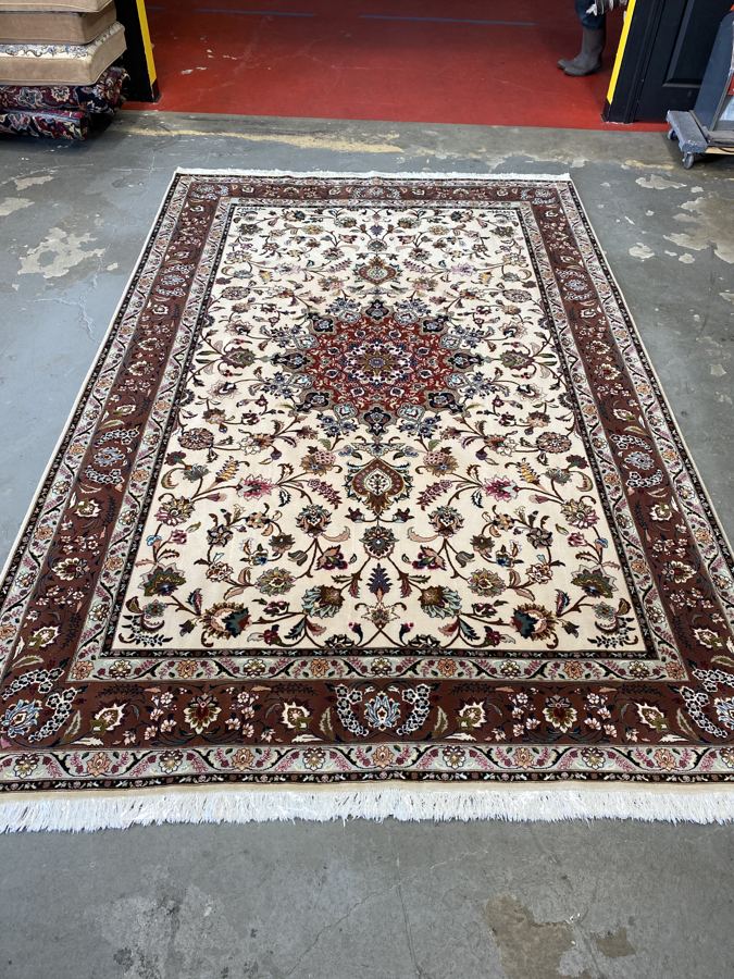 The same ivory Tabriz rug after shearing, with a rich brown border