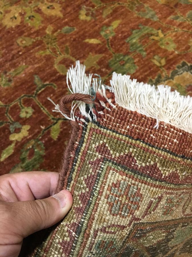Damaged rug corner with loose fringe